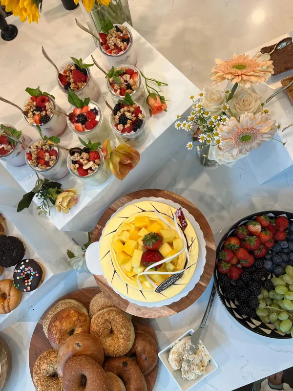 Mesa de brunch com frutas, doces e flores